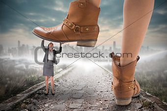 Composite image of cowboy boots stepping on businesswoman