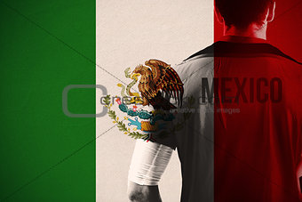 Composite image of mexico football player holding ball