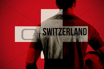 Composite image of swiss football player holding ball