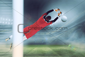 Composite image of goalkeeper in red jumping up
