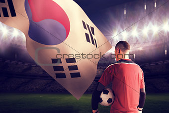 Composite image of goalkeeper in red holding the ball
