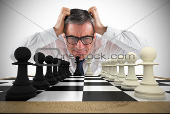 Composite image of stressed businessman touching his head