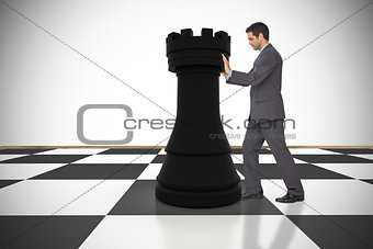 Composite image of businessman pushing chess piece