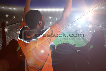 Composite image of cheering football fan in orange jersey