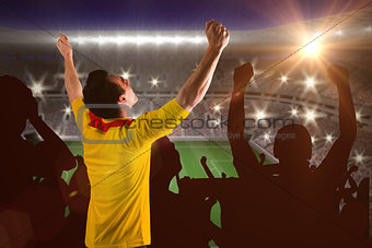 Composite image of cheering football fan in yellow jersey