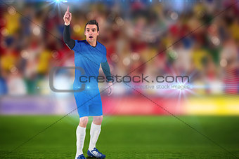 Composite image of football player raising his hand