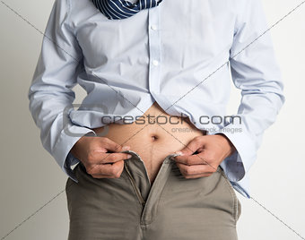 Man trying to fasten pants