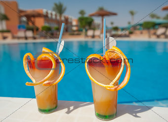 Two fruit cocktails by pool