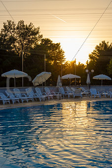 Swimming pool in the rays of the setting sun