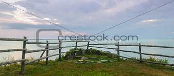 Panorama of a wooden fence on ocean shore in the morning