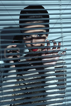 sexy spy woman behind shutters 