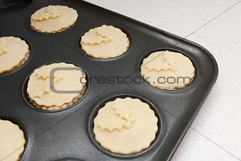 Mince pies in a bun tin ready for the oven