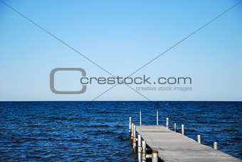 Wooden bath pier in blue water