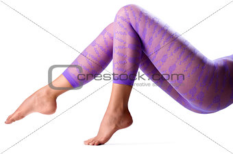 Female legs in purple leggings over white background