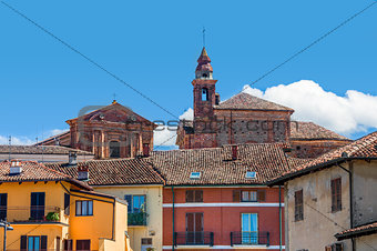 Church's bell tower and colorful houses in La Morra.