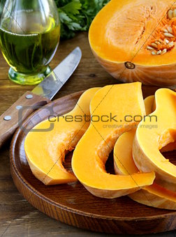 fresh raw pumpkin sliced on a wooden table