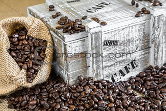 burlap bag filled with coffee beans beside old wooden box