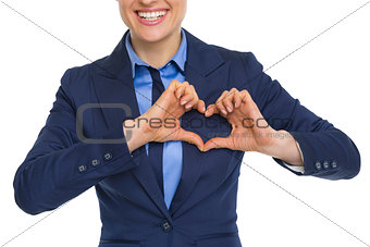 Closeup on happy business woman showing heart with fingers