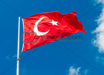 Waving flag of Turkey over blue sky background