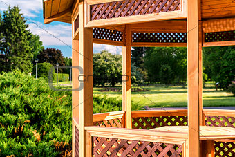 Outdoor wooden gazebo over summer landscape background