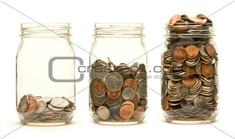 Three glass jars holding coins