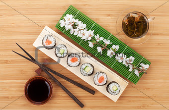 Sushi set with green tea and sakura branch