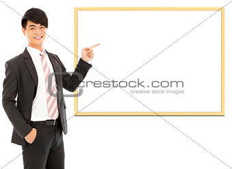 asian smiling businessman pointing blank board