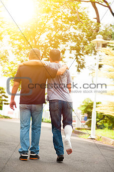 friend helping brothers or patient  to walk on the road