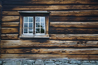Dark country timbered wooden loghouse wall with window