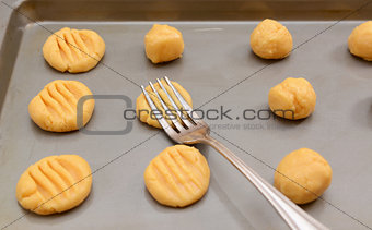Flattening balls of cookie dough 