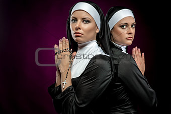Portrait of two attractive young nuns praying