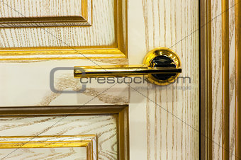 gilded handle on the beige interior door