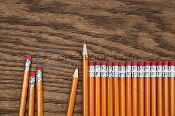 A row of red pencils on wood surface
