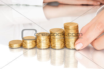 Hand putting a coin isolated on a blue background
