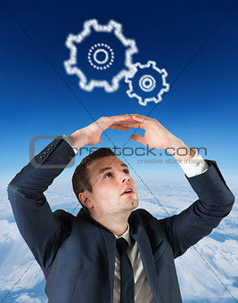 Composite image of businessman standing with hands over head