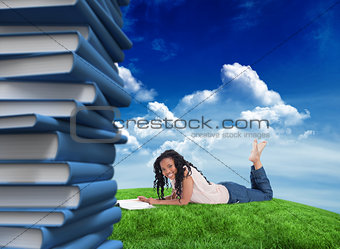 Composite image of a woman lying on the floor smiling at the camera with a magazine in front of her