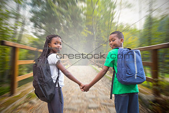 Composite image of cute pupils holding hands