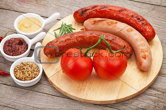 Various grilled sausages with condiments and tomatoes