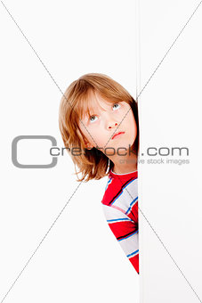 Boy Peeking Out From Behind A White Board Looking Up