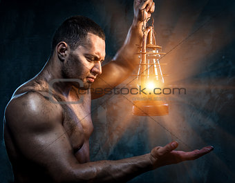 Muscular man holding oil lamp