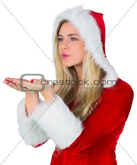 Pretty girl in santa outfit blowing