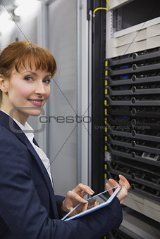Pretty technician using tablet pc while working on servers