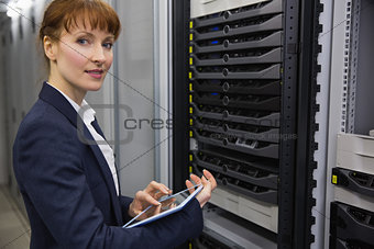 Pretty technician using tablet pc while working on servers