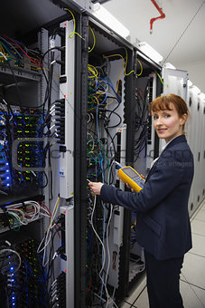 Happy technician using digital cable analyzer on server