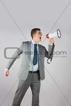 Angry businessman shouting through megaphone