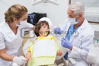 Terrified little boy looking at needle in dentists chair