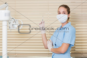 Dental assistant holding injection looking at camera