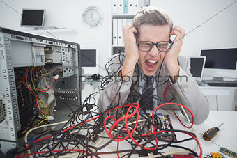 Stressed computer engineer working on broken cables