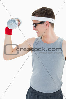Nerdy hipster lifting heavy dumbbell