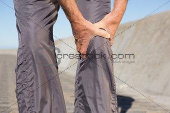 Active senior man touching his injured knee